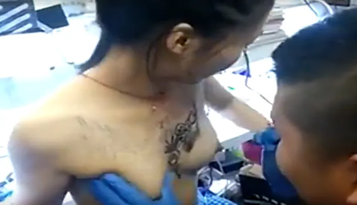 What a bold molester! The pretty girl's chest tattoo is directly exposed! The tattoo artist couldn't stand it at first glance: the tattoo needle hasn't started yet, but he pinched first.